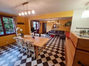 a kitchen and living room with a wooden table and chairs at Gîte de l'orangerie du château de Jallanges- 11 personnes in Vernou-sur-Brenne