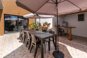 einen Tisch und Stühle mit Sonnenschirm auf einer Terrasse in der Unterkunft Sevenfarm in Mangualde