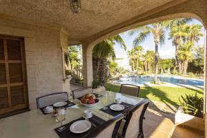 an outdoor dining room with a table and a view of a pool at Villa Can Gual Family Suite in Inca