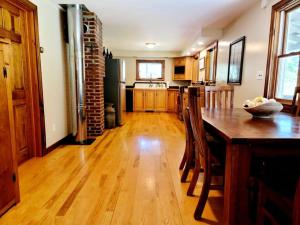 a kitchen with a wooden floor and a table with chairs at Hiking, MTB, four wheeling, fishing lakes, beaches, skiing, snowboarding, in Barton