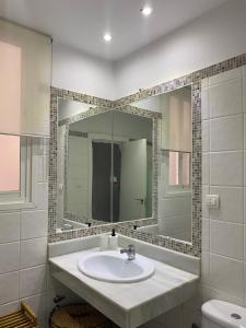 y baño con lavabo y espejo. en PRECIOSO Y ACOGEDOR APARTAMENTO EN PLENO CENTRO DE GRANADA, en Granada