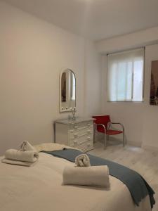 1 dormitorio con cama, tocador y espejo en PRECIOSO Y ACOGEDOR APARTAMENTO EN PLENO CENTRO DE GRANADA, en Granada