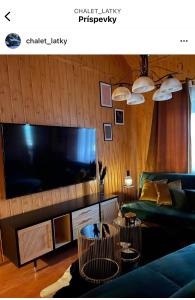 a living room with a couch and a large flat screen tv at Chalet Látky in Látky
