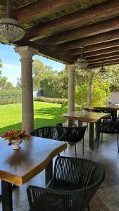 a patio with tables and chairs under a wooden pergola at Maja Hotel Boutique in Morelia