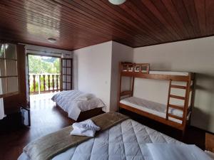 a bedroom with two bunk beds and a balcony at Pousada Campos de Paiva in Campos do Jordão