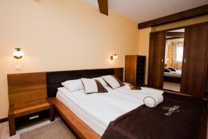 una camera da letto con un grande letto e un grande specchio di Bell Tower at BlackSeaRama Golf&Villas a Balchik Altre 17 foto