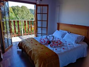 a bedroom with a large bed with a large window at Pousada Campos de Paiva in Campos do Jordão