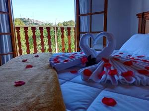1 dormitorio con 2 camas con rosas en Pousada Campos de Paiva, en Campos do Jordão