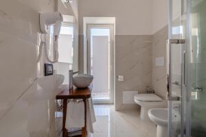 a white bathroom with a sink and a toilet at La Casa di Armida Boutique homes con sauna in Naples