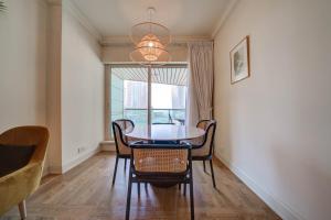 a dining room with a table and chairs and a window at Stunning 2BR l Marina View in Dubai