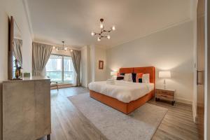 a bedroom with a large bed and a chandelier at Stunning 2BR l Marina View in Dubai +11 photos