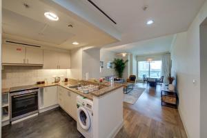 杜拜的住宿－Stunning 2BR l Marina View，厨房以及带洗衣机和烘干机的客厅。