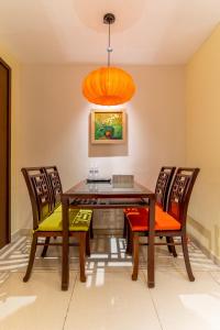 a dining room with a wooden table and chairs at The Rixx Indochine Apartment with Balcony and Rooftop Pool in Ho Chi Minh City