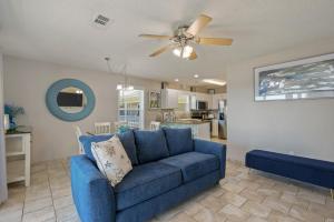 Sofá azul en la sala de estar con ventilador de techo en 200 yds to private gated beach access- 3BR-2BA- quiet location in the heart of Destin! en Destin