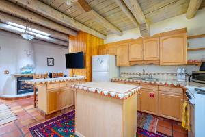 a large kitchen with wooden cabinets and a refrigerator at Besos on Canyon Road in Santa Fe