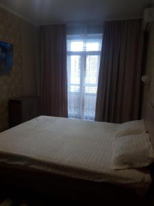 a bedroom with a white bed and a window at comfortable apartment in Chişinău
