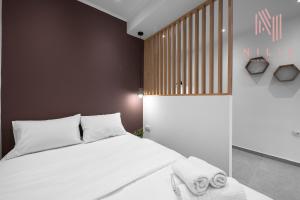 um quarto com uma cama com lençóis brancos e toalhas em Bourn, Nilie Hospitality MGMT em Tessalônica
