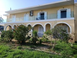 a house with trees in front of it at ALMIRIKI Studios & Apartments in Alykes