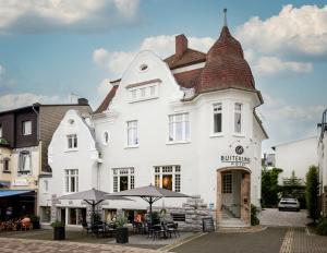 a white building with a brown roof at BUITERLING Hotel in Brilon