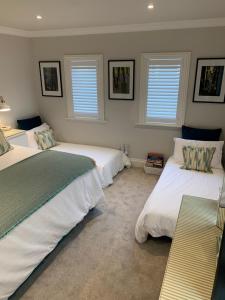 a bedroom with two beds and two windows at Hideaway Holiday Apartment in Salisbury