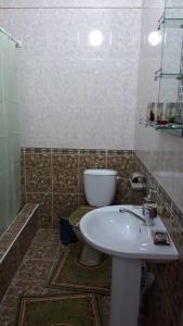 La salle de bains est pourvue d'un lavabo blanc et de toilettes. dans l'établissement Гостиница NUR, à Aralʼsk
