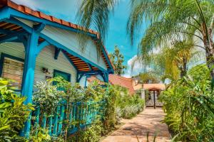 a blue house with a fence and palm trees at H&ocirc;tel Bambou & Spa in Les Trois-&Icirc;lets