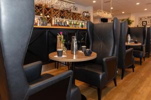 um restaurante com cadeiras pretas e uma mesa de madeira em Skagen Villa & Apartments em Skagen
