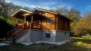 ein kleines Holzhaus mit einer Veranda und einer Treppe in der Unterkunft Riverside Forest Retreat-Chalet in Karpenisi