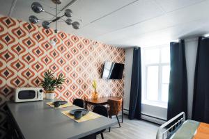 a dining room with a table and a tv on a wall at LOFT LE RÉTRO du Centre-Ville in Quebec City
