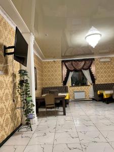 Гостиница NUR في Aralʼsk: غرفة معيشة مع تلفزيون وطاولة