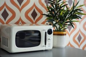 a white microwave sitting on a table next to a potted plant at LOFT LE RÉTRO du Centre-Ville in Quebec City +19 photos