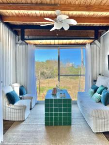 a living room with a couch and a ceiling fan at Blue in José Ignacio