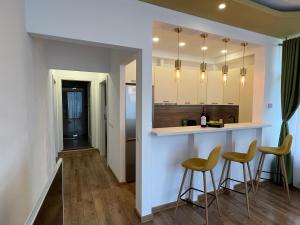 a kitchen with two stools and a bar in a room at Patri’s Apartment in Şelimbăr
