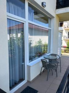 a patio with a table and chairs and a window at Patri’s Apartment in Şelimbăr