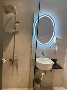 a bathroom with a sink and a shower with a mirror at فندق المنصور in Aḑ Ḑabbīyāt al Janūbīyāt