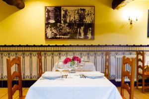 un comedor con una mesa blanca con flores. en Rectoral de Fofe, en Fofe