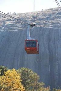 a red cable car going up a mountain at #2BR Cozy Villa - Mins to Historic STM Amusement Park! in Stone Mountain