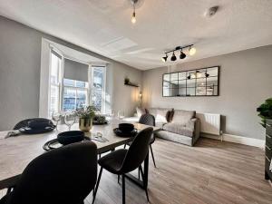 een woonkamer met een tafel en stoelen en een bank bij Three Bedroom House Next to Brighton Station slp 9 in Brighton & Hove