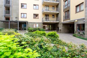 un edificio de apartamentos con jardín frente a él en Comfy Apartment Dobra 54, en Varsovia