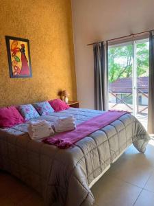 1 cama grande en un dormitorio con ventana en Departamento duplex en Villa General Belgrano