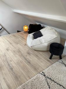 salon z białą kanapą na drewnianej podłodze w obiekcie Maisonnette Les garages w mieście Namur