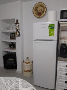 - un réfrigérateur blanc dans la cuisine équipée d'une cuisinière dans l'établissement Casa Rural "La Casita", à Pujerra
