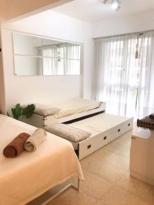 1 dormitorio con 2 camas y espejo en Impecable Monoambiente en inmejorable ubicación en Mar del Plata