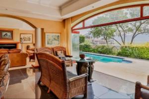 a living room filled with furniture and a large window at Pecanwood villa on Hartbeespoort Dam in Hartbeespoort