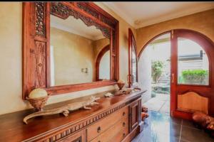 a bathroom with a large mirror and a wooden dresser at Pecanwood villa on Hartbeespoort Dam in Hartbeespoort