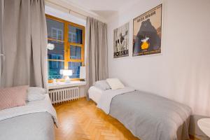 een slaapkamer met 2 bedden en een raam bij Apartamenty - MI Forest in Warschau