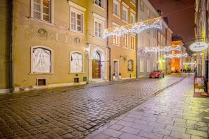 una calle vacía por la noche con luces de Navidad en Apartamenty - MI Forest en Varsovia