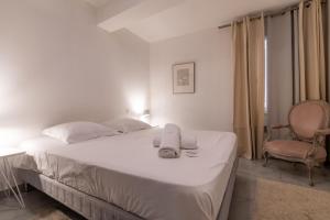 um quarto branco com uma cama e uma cadeira em APPARTEMENT T2 SPACIEUX ET COSY - HYPER-CENTRE - FREE WIFI - 2 pers em Avignon