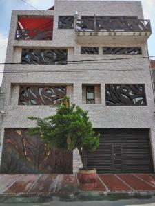 ein Gebäude mit einem Baum davor in der Unterkunft Gran México in Mexiko-Stadt