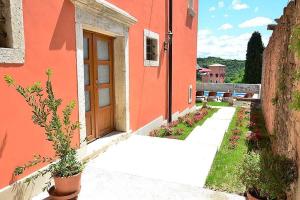 an orange building with a door and a courtyard at Villa Letizia in Oprtalj